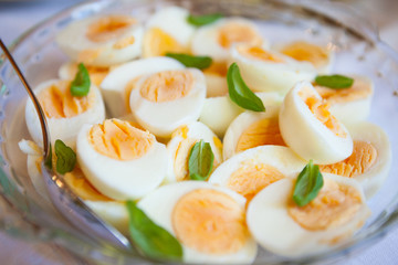 Boiled eggs sliced half and basil leaves