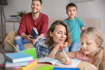 Fototapeta premium Little children with parents doing homework at home
