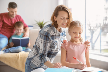 Obraz premium Little girl with mother doing homework at home