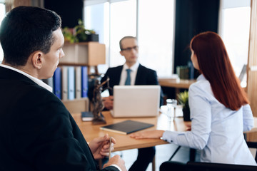 Young serious couple consults, sitting in office of divorce advocate. Adult couple is divorced.