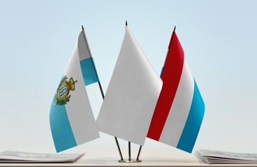 Flags of San Marino and Luxembourg with a white flag in the middle