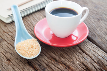 Spoon of brown sugar with a cup of coffee, Unhealthy concept