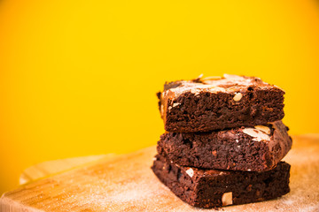 Closeup photo of the chocolate brownies with the sliced almond sprinkling on top on wooden...