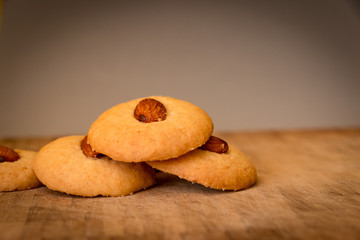 Simple butter cookies with almond on top on wooden tray. The closeup photo of homemade butter cookies.