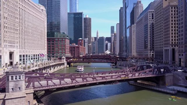An aerial over the Chicago River and riverboats in downtown Chicago.
