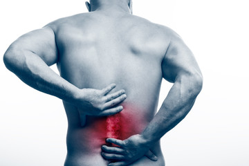Injury of the spine. Young bald man sports physique holds a sick back on a white isolated background. Fracture of spine