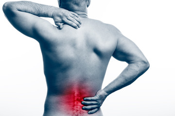 Pain in the spine.  Young bald man sports physique holds a sick back on a white isolated background. Fracture of spine