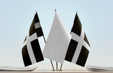 Two flags of Cornwall with a white flag in the middle