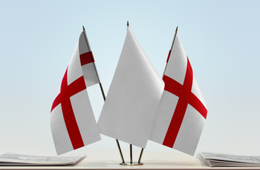 Two flags of England with a white flag in the middle