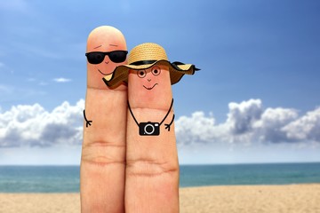 Happy finger couple face on vacation at the beach