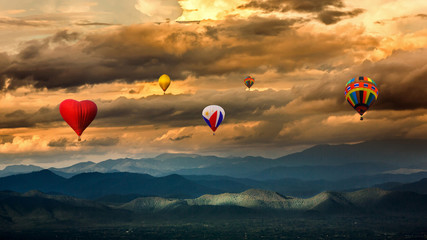 Dramatic Sunset Sky and Clouds with Colorful hot air balloons flying over mountains landscape