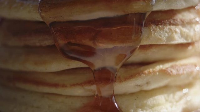 Stack of pancakes with maple syrup dripping down.