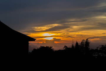 Silhouette home and tree with beautiful sunset