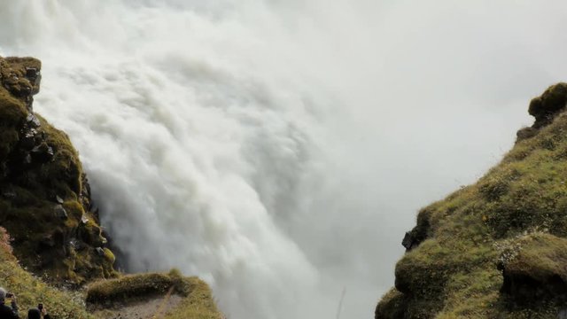 rapid flow of powerful waterfall between two rocks covered moss, epic view