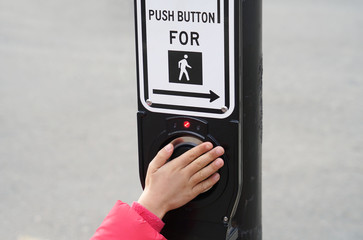 Kids hand push button of pedestrian crossing sign 