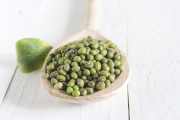 dry green grain masha in a wooden spoon on the table