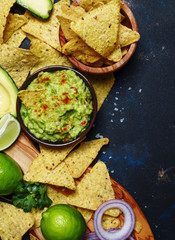 Mexican food, guacamole sauce with avocado, onion, garlic and chili, black background, top view