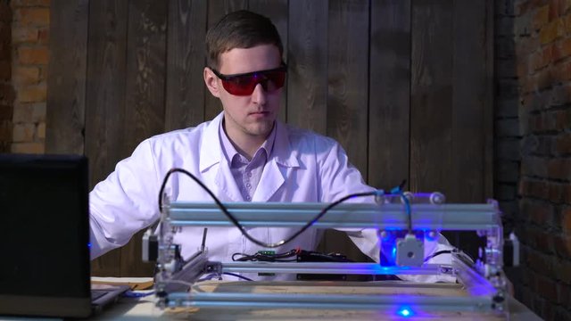 The laser does engraving on the skin. The operator of the laser machine.