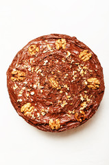 Homemade chocolate cake with nuts, white background, top view