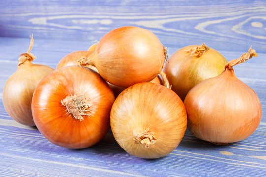Heap of onions on purple boards, healthy nutrition