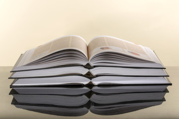 Three open books on a yellow background