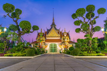 One of the famous temple in Wat Arun Ratchawararam with two giants statue in the front during twilight time
