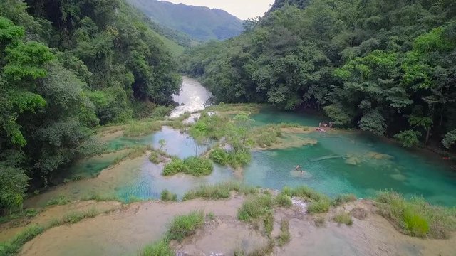 An aerial over remarkable waterfalls and green polls on the Semuc Champey river in Guatemala.