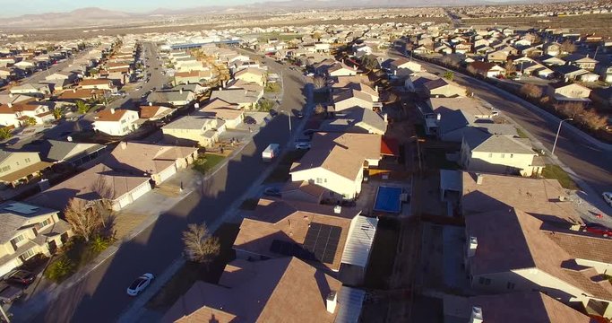 Aerial over vast desert housing tracts suggests suburban sprawl.