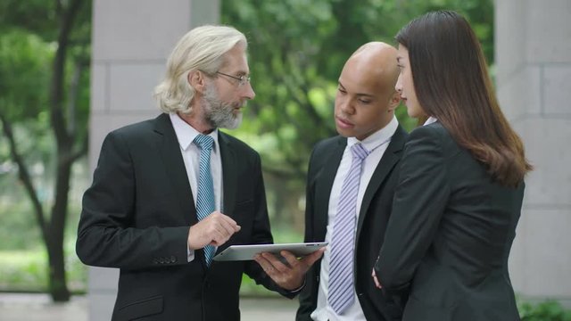 Corporate executives discussing business using a tablet