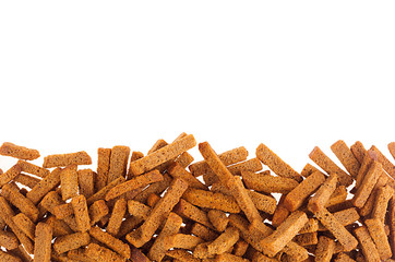 Crunchy rye croutons heap as decorative border with copy space, isolated on white background.