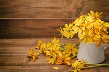yellow gardenia flower in vase on wooden background with copy space