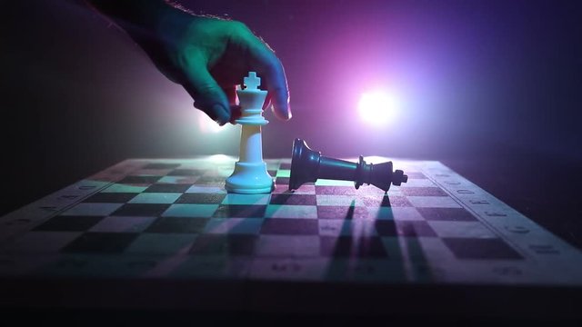 Slider shot. Chess board game concept of business ideas and competition and strategy ideas concept. Chess figures on a dark background with smoke and fog. Selective focus