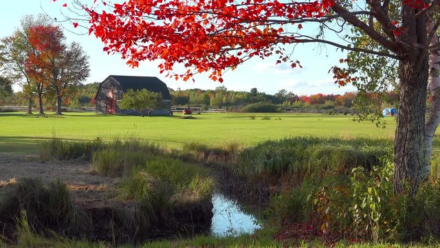 A pretty old barn and farmhouse in fall in rural Maine.