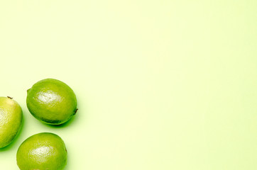 green limes om a green pastel background