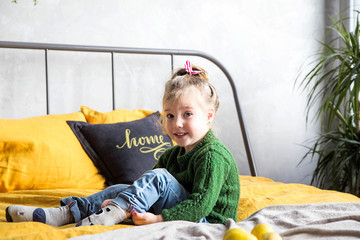 little girl is sitting on the bed and clothes socks © ribalka yuli