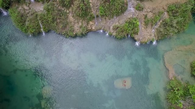 An aerial over remarkable waterfalls and green polls on the Semuc Champey river in Guatemala.