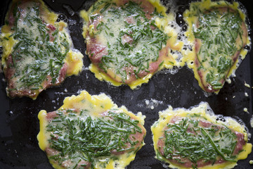 Sliced  seasoned beef with wheat flour and egg to fry, garnished with chives