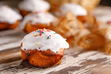 Fresh pastries with sugar icing on a wooden background.