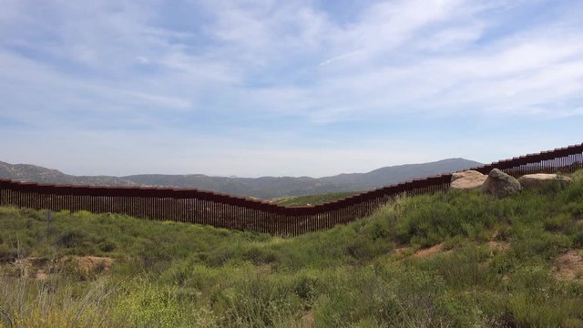 Establishing shot of the U.S. Mexico border wall fence near Tecate Mexico.