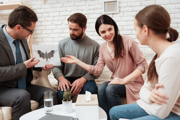 Little girl pass Rorschach test together with her parents in office of family psychologist.