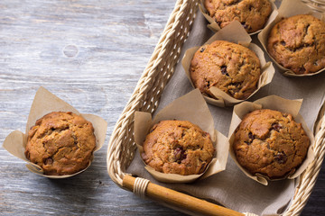 Homemade buckwheat muffins with dried fruits in a basket on a wooden table, top view, free space, selective focus