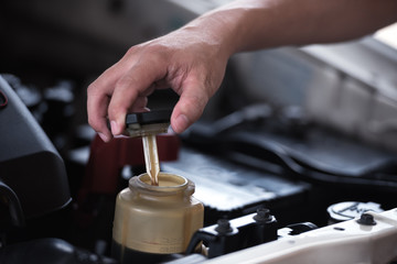 Man hand open power steering cap up for checking level of power steering fluid in the system, car...