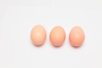 three chicken eggs on a white background
