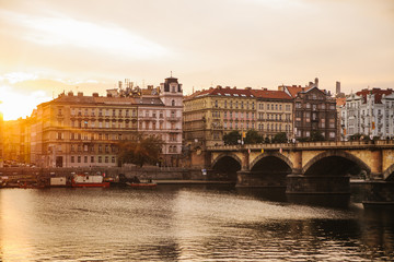 Fototapeta na wymiar Beautiful view of the architecture of Prague in the Czech Republic at sunset. Traditional houses and a bridge across the Vltava River.
