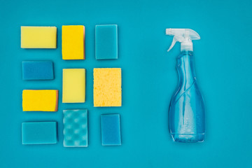 top view of spray bottle and washing sponges isolated on blue