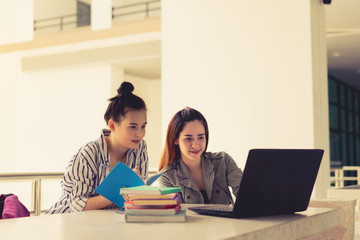 Obraz premium Student women teamwork together working study online or homework with laptop computer and meeting in university campus indoor