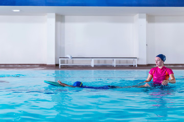 Boy having a swimming lesson with instructor
