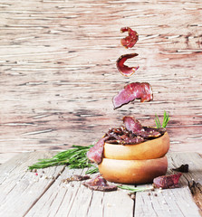 jerked meat, cow, deer, wild beast or biltong in wooden bowls on a rustic table, selective focus