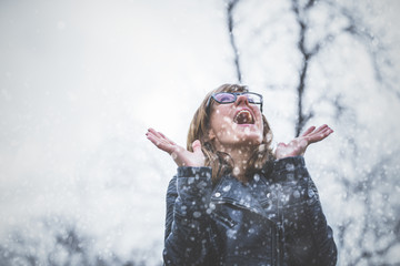 Fototapeta premium Snow falling and cute girl feeling happy outdoors.