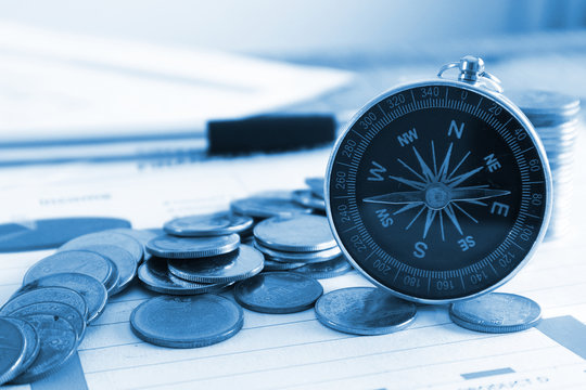 Close up compass and coin stack on income document , finance concept.